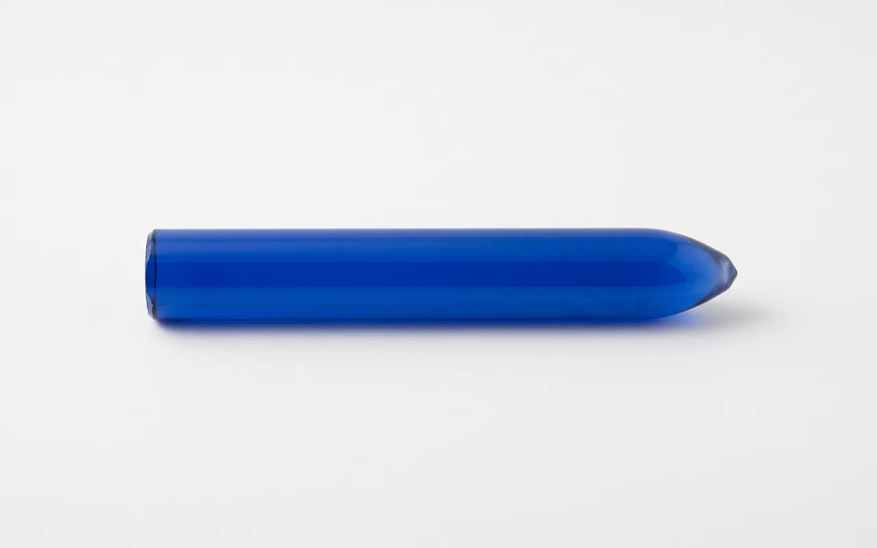 Lab-grown synthetic sapphire boule — a solid cylinder of blue corundum — on a white ground